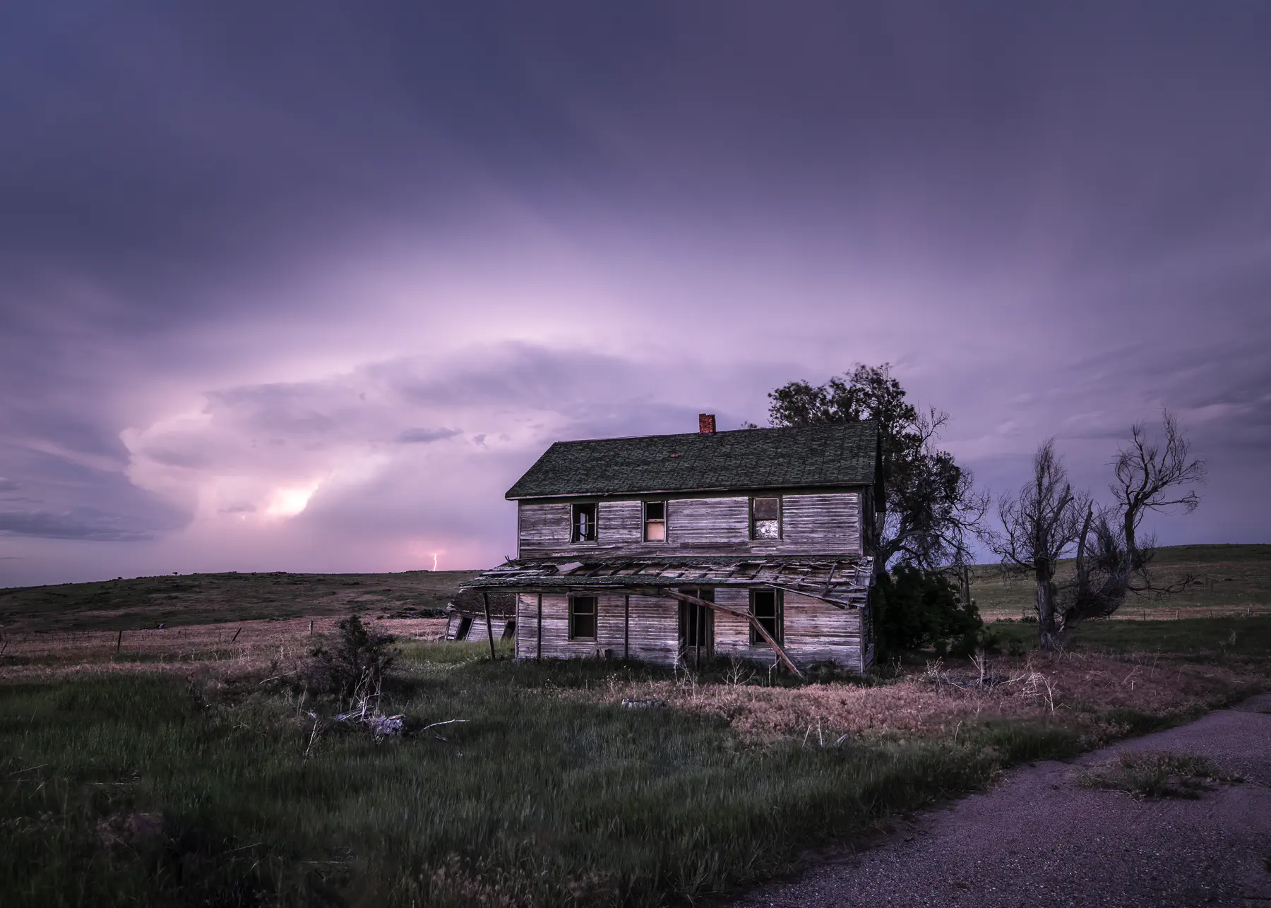 Abandoned house with distant lightning